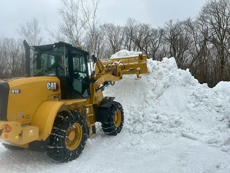 トラクターで路上の深い雪を除雪している様子