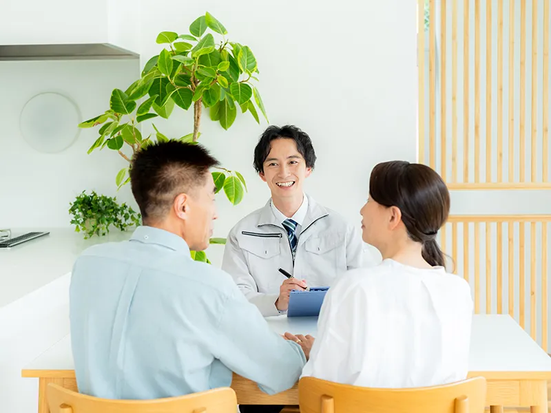室内でリフォームの打合せをしている、夫婦と施工事業者の様子
